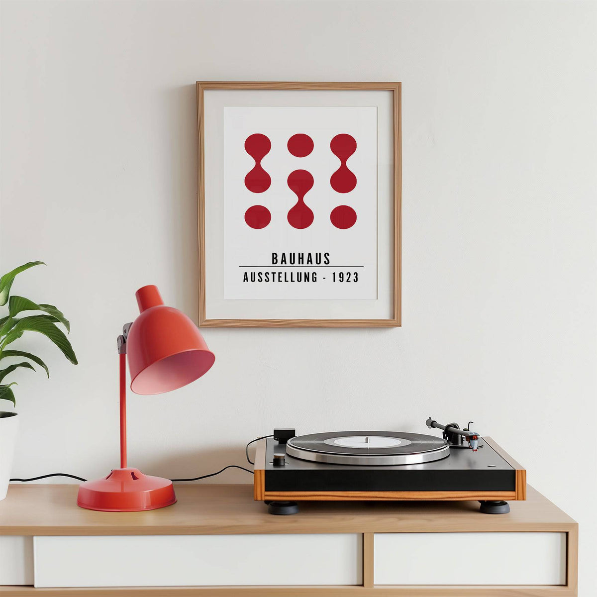 Artwork for Office Walls framed print with red abstract shapes above a wooden desk with a red lamp and record player