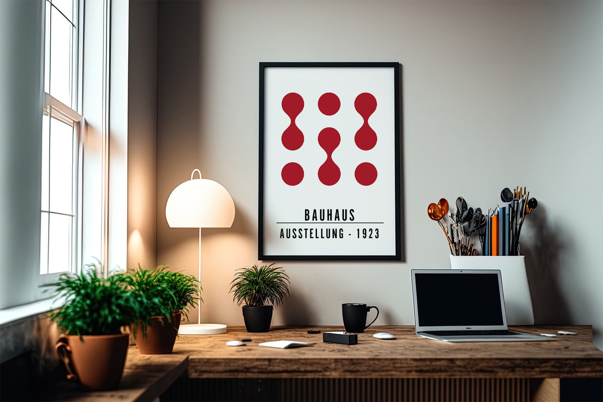 Artwork for Office Walls framed print with red abstract shapes and text above a desk with plants and a lamp