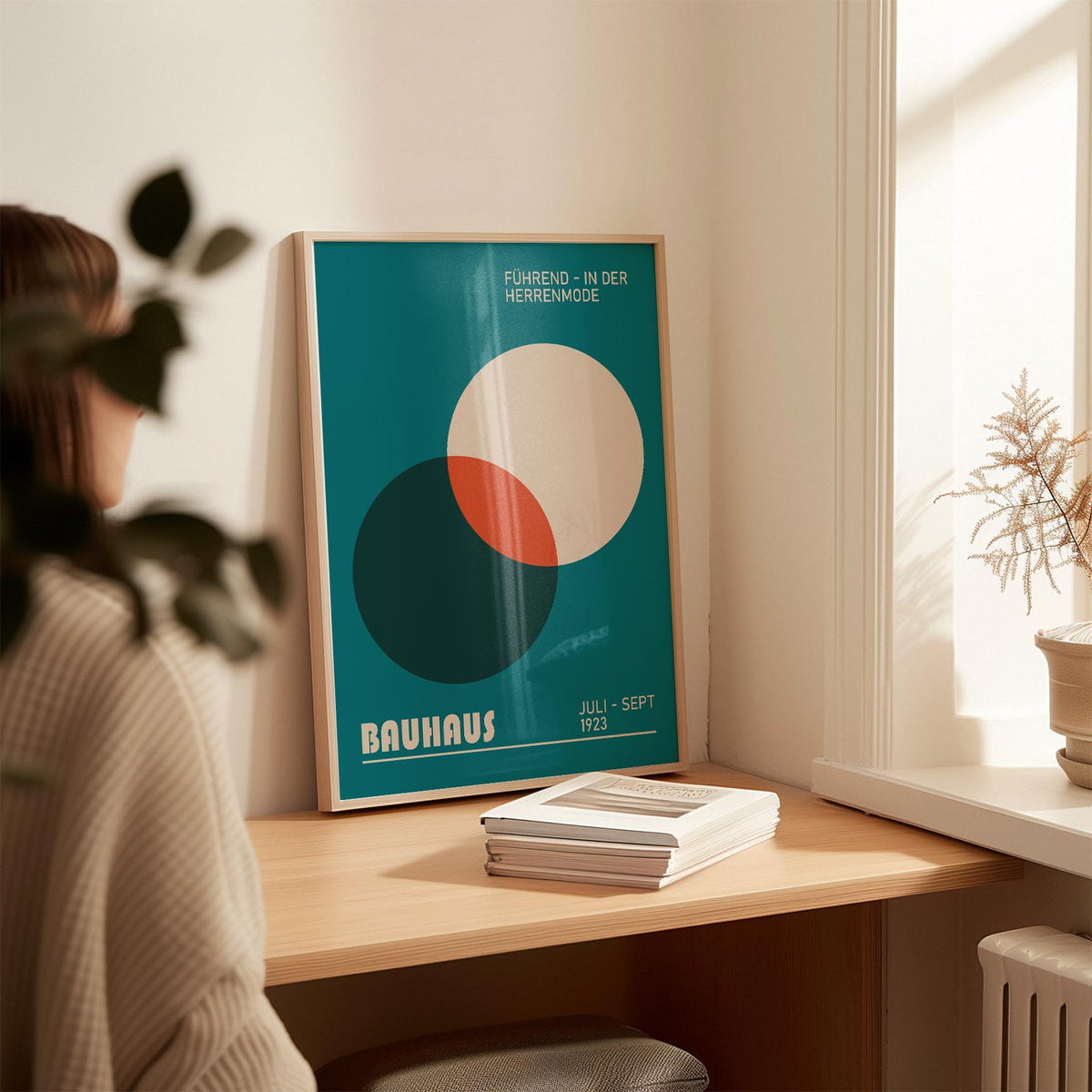 Modern Office Wall Art leaning on a wooden desk with overlapping muted blue, white and rust circles with books nearby