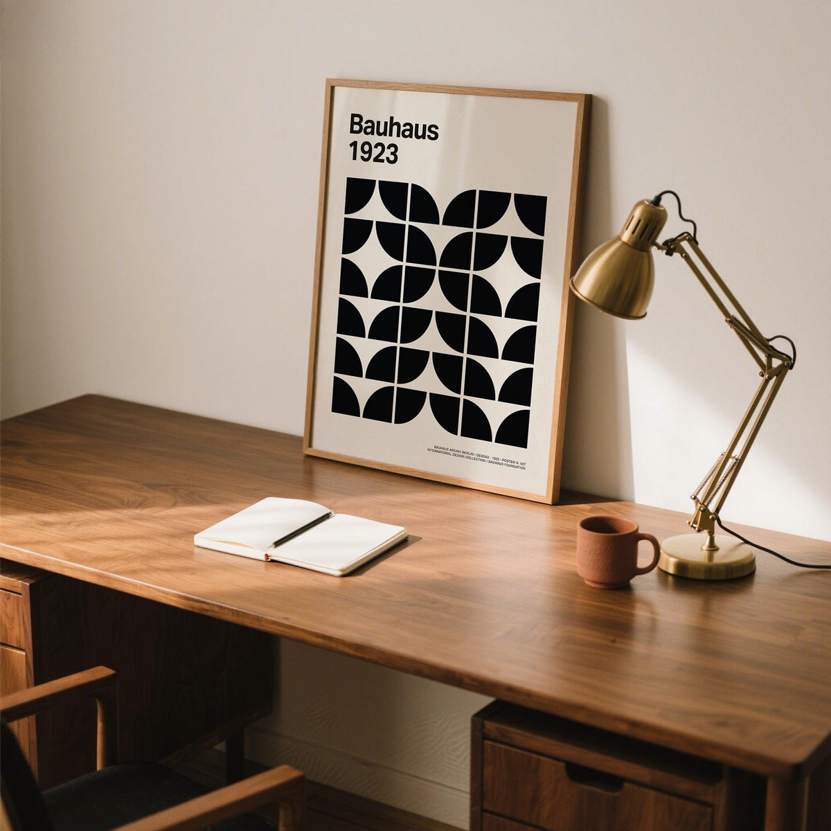 Mid Century Art Prints leaning print with black geometric shapes on beige beside a brass desk lamp