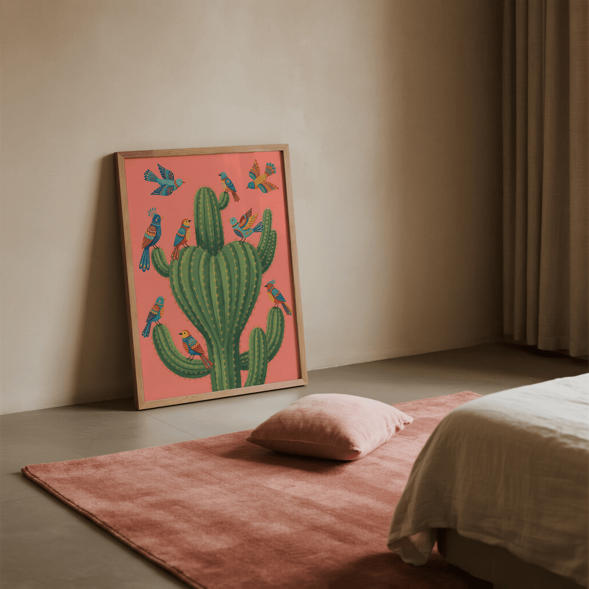 Print leaning on the floor of a bedroom featuring colorful birds on a green cactus with a pink background alongside a cushion