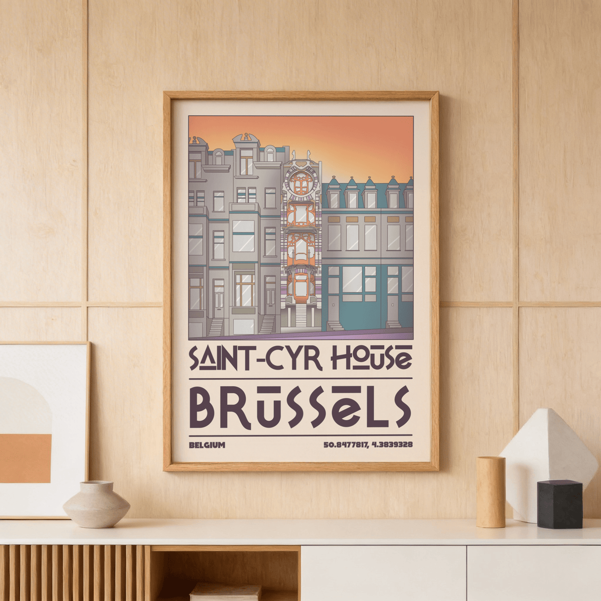 Saint Cyr House Poster illustrated in grey and orange tones with a wooden frame on a light wood panel wall