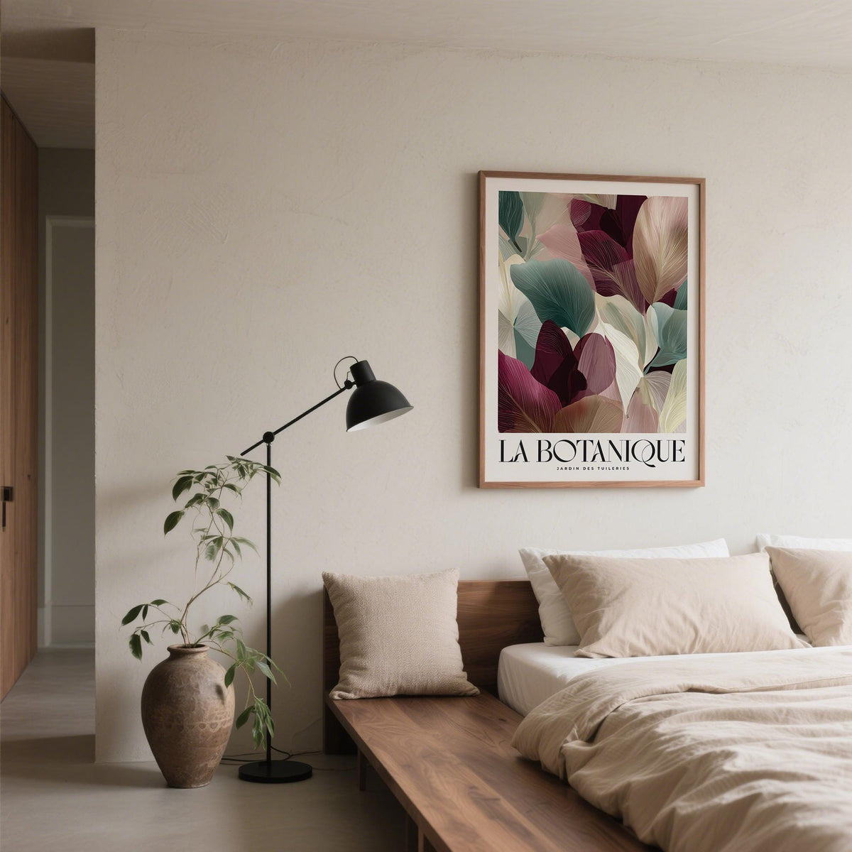 Burgundy wall art of abstract leaves in shades of burgundy green and cream above a wooden bed
