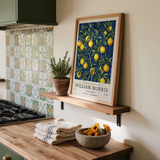 Lemon wall art with bright lemons and green leaves leaning on a kitchen shelf near a plant pot
