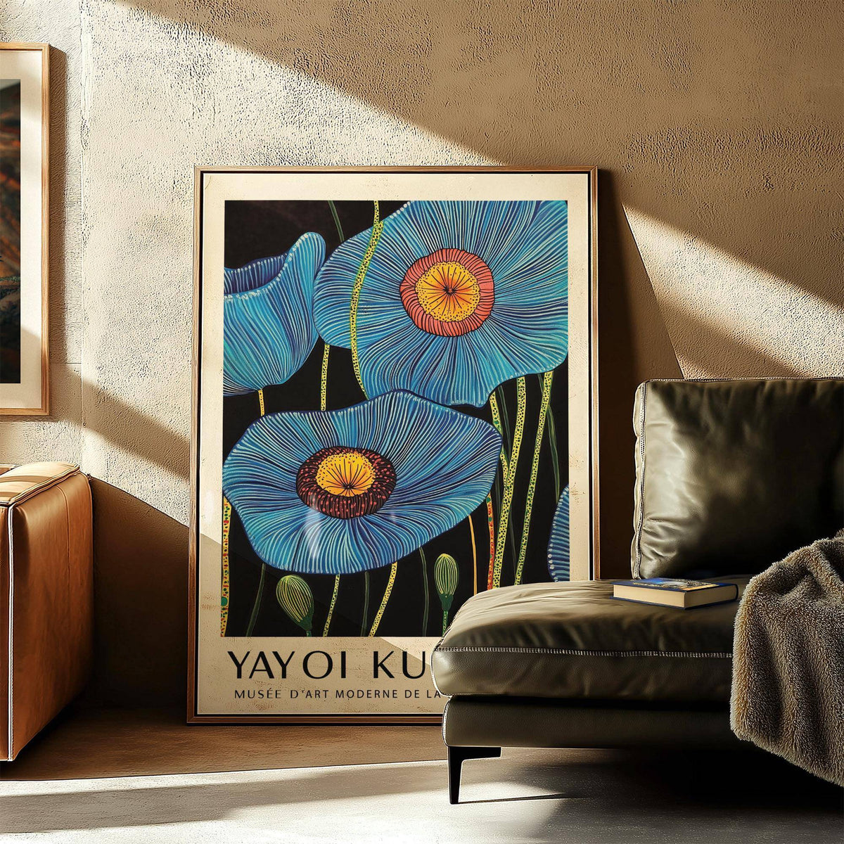 Big flower wall art leaning in a living room with blue poppy flowers and a leather sofa nearby