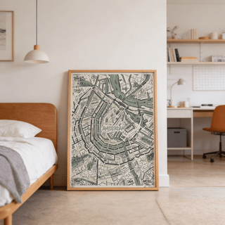Print leaning on a floor showing Amsterdam Map Art Print in muted green, black and beige tones in a bedroom