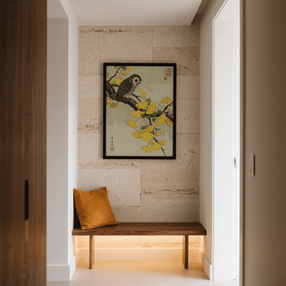 Print on a wall in a hall with an owl on a ginkgo branch in Japanese woodblock style above a wooden bench with a cushion