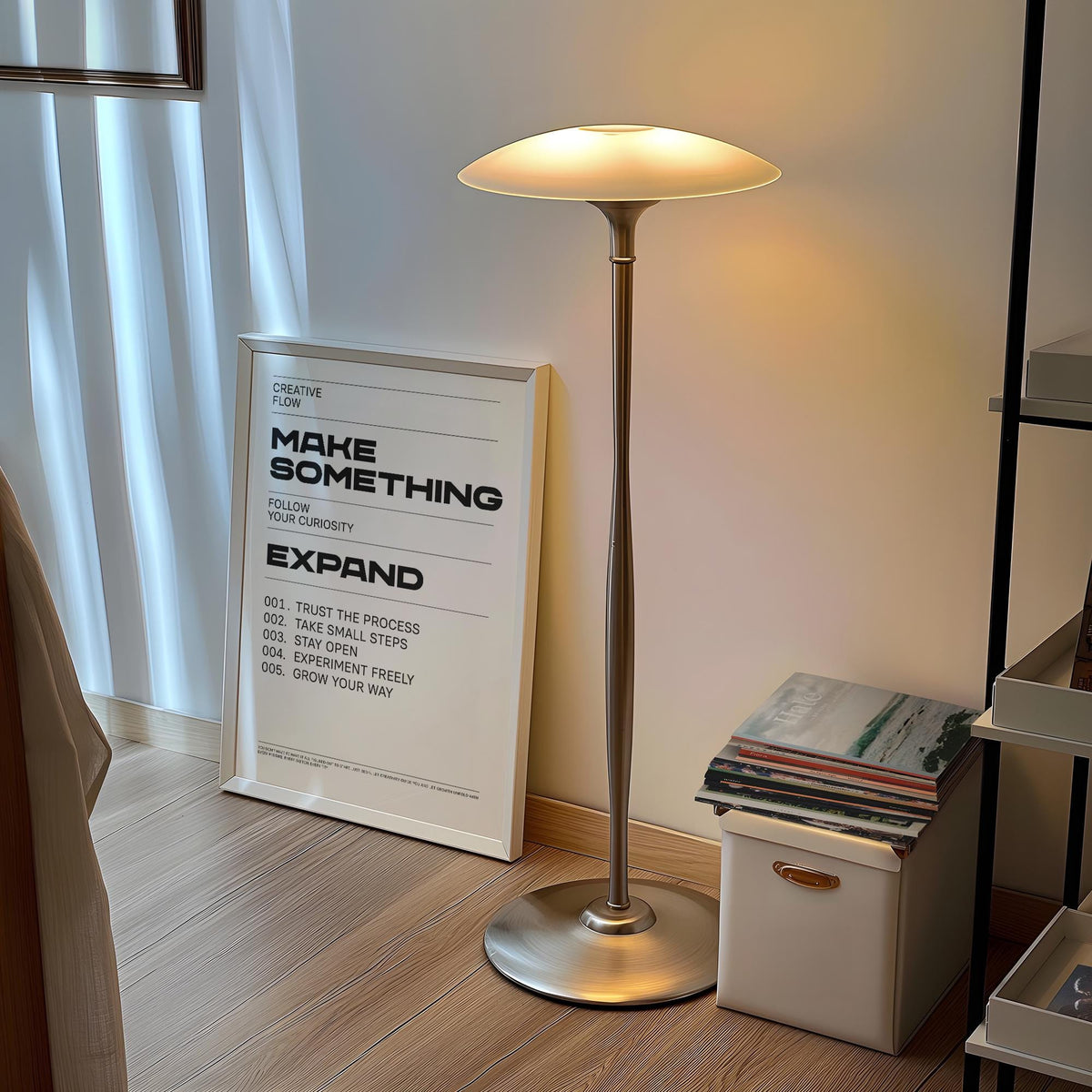 Quotes for Room Wall print leaning on a wooden floor beside a lit silver lamp and magazines on a box
