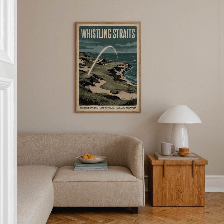 Lakeside Links Golf Poster vintage illustration of a coastal golf course above a beige sofa and wooden side table in a living room