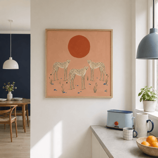 Print on a wall of cheetah art print with three cheetahs under a red sun in a kitchen with a blue toaster