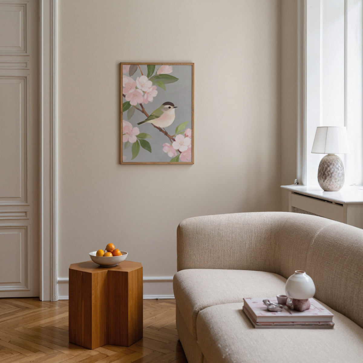 Botanical Bird wall art of a small bird on a branch with pink blossom in a living room above a wooden side table