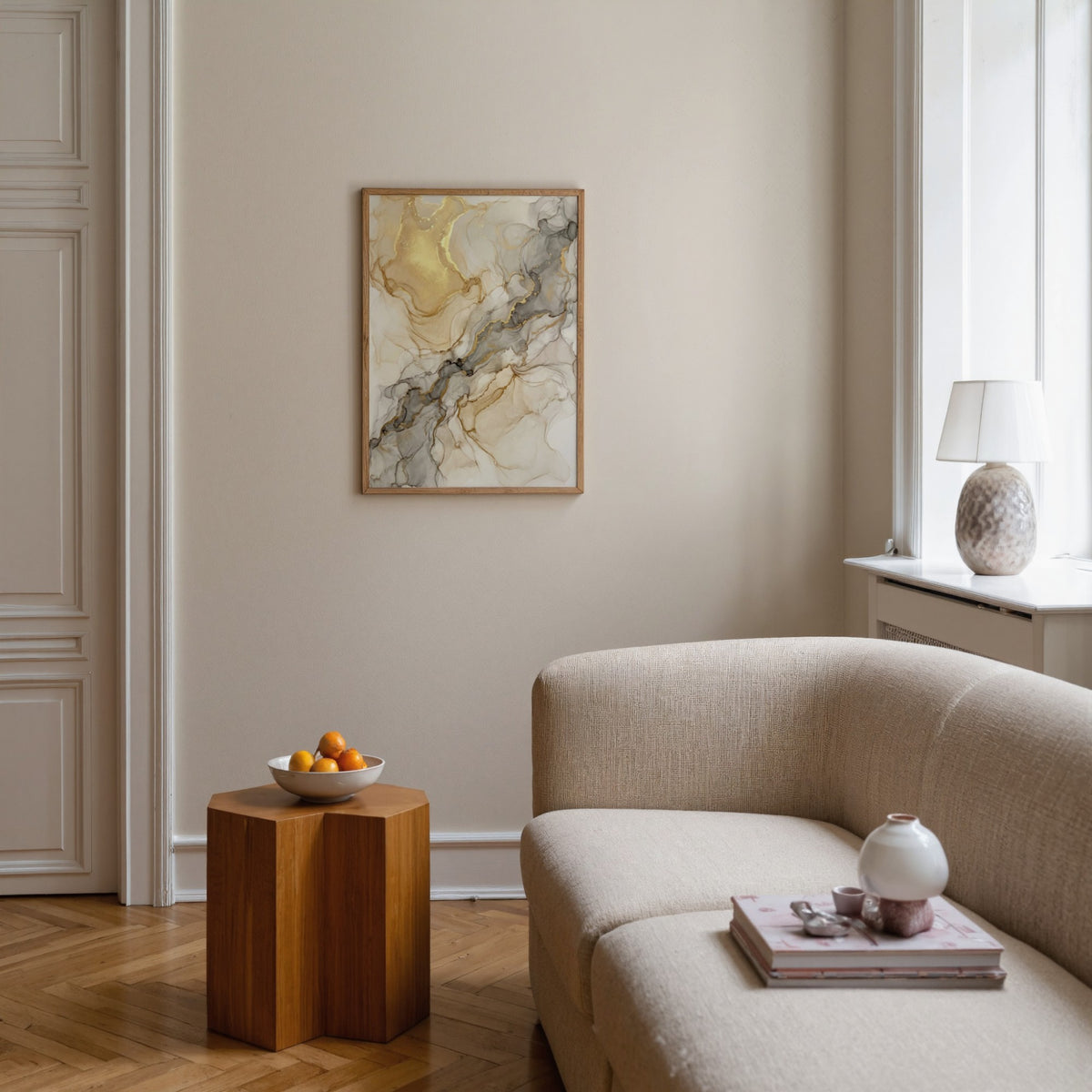 Beige Abstract Print framed on a neutral wall above a wood side table with fruit bowl in a living room