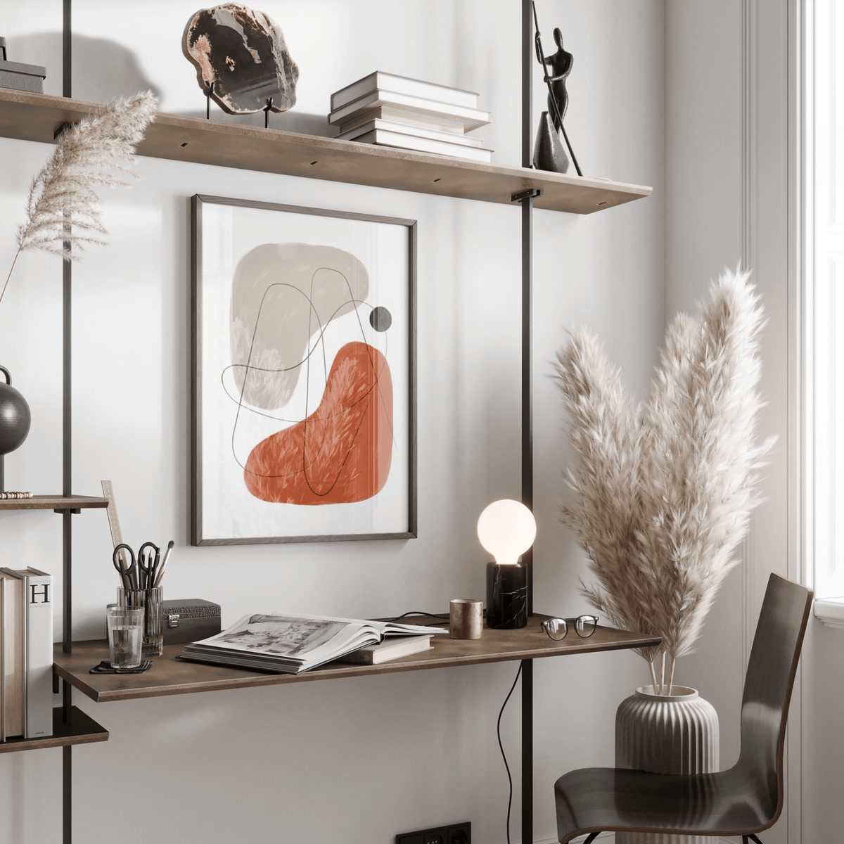 Simple Abstract Art on a wall with brown and beige shapes above a desk with a lamp and pampas grass