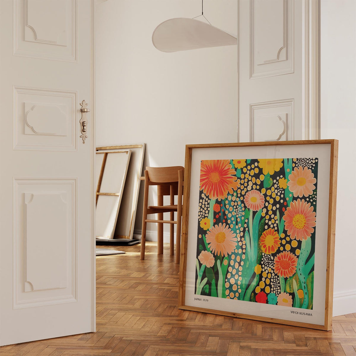 Flowers print leaning on floor near chair with orange and pink floral design
