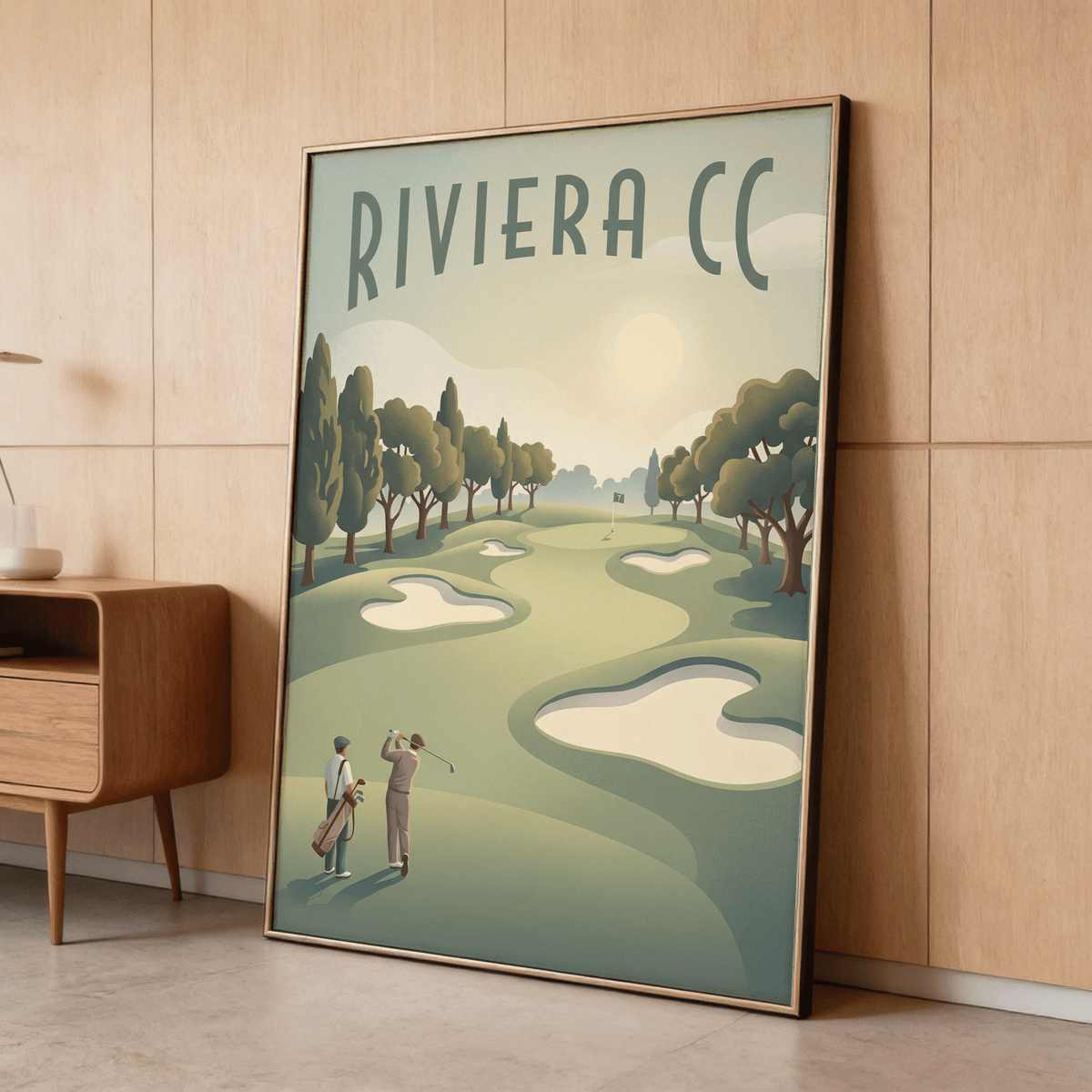 Framed Golf Landscape Poster leaning against wall with two golfers on a course in green and beige tones alongside a wooden cabinet