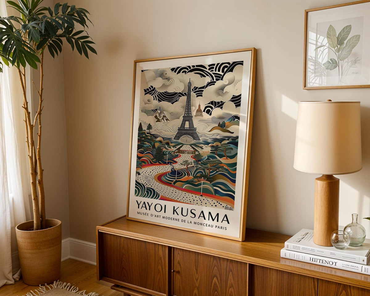 Eiffel Tower Print leaning on a wooden cabinet with a lamp and plant nearby in soft light
