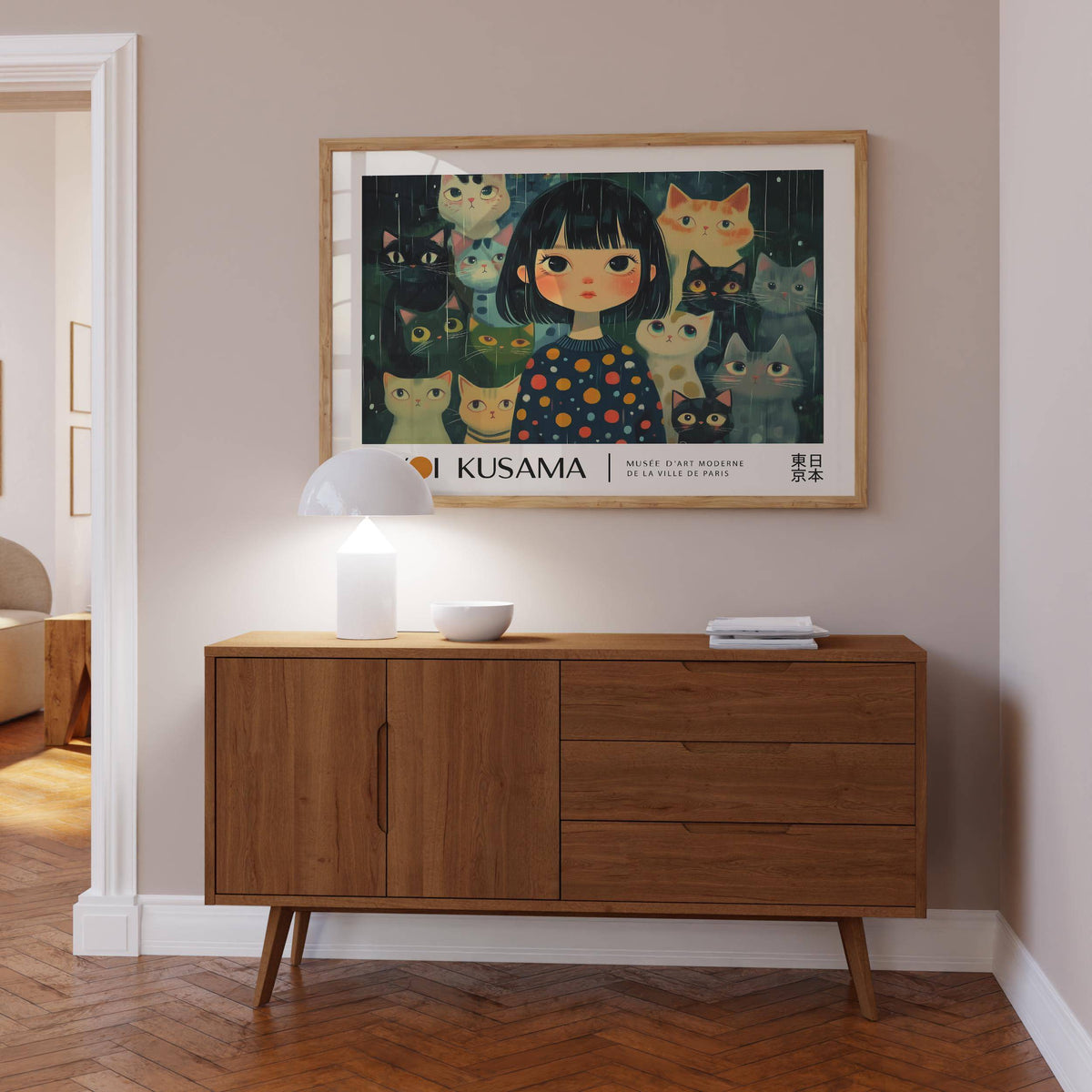 Unique Wall Art of a girl with cats in dark colours framed above a sideboard with a lamp