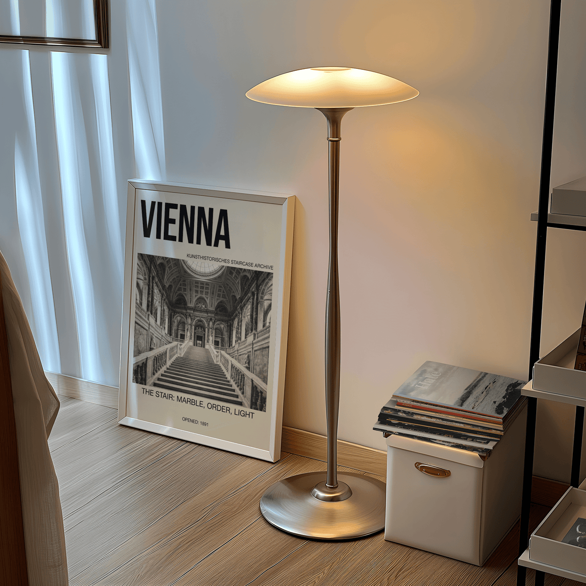 Print leaning on a floor next to a silver lamp showing a marble staircase in black and white