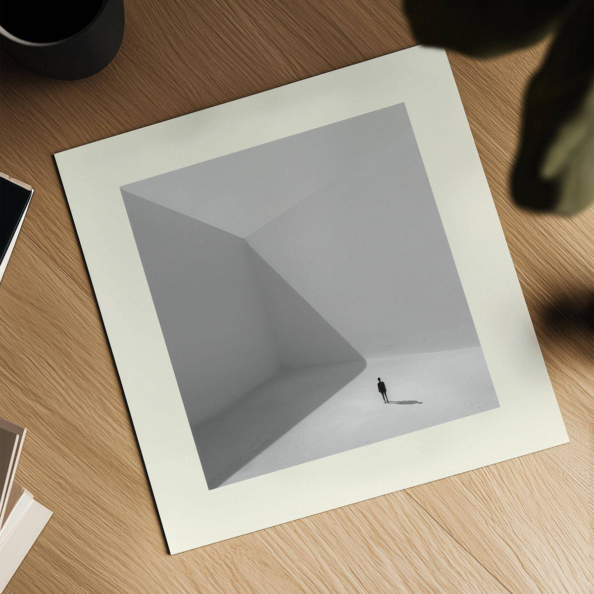 Square Art Prints of a solitary man casting a shadow in a minimalist grey and white space on a wooden surface