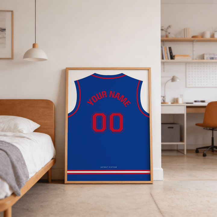 Basketball Jersey Poster in Blue with Red Number leaning against a wall near a brown bed in a bedroom