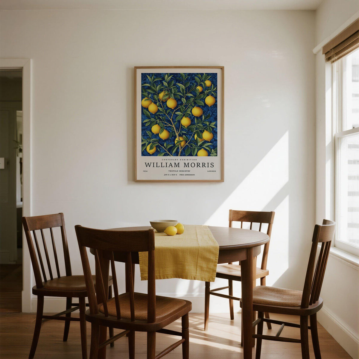 Lemon wall art illustration of a branch with yellow lemons and green leaves in a dining room above a table with a yellow runner and bowl