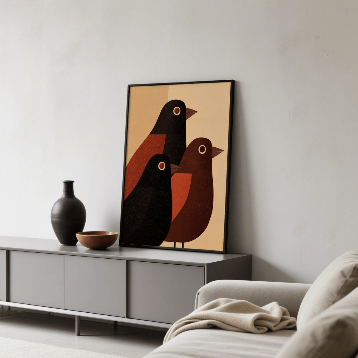 Abstract Bird wall art leaning on a grey sideboard with a black vase and bowl in a living room