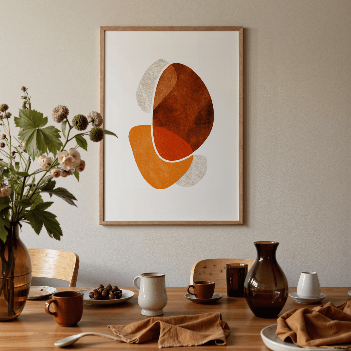 Contemporary Abstract Poster with organic shapes in warm tones above a dining table with crockery and a flower vase