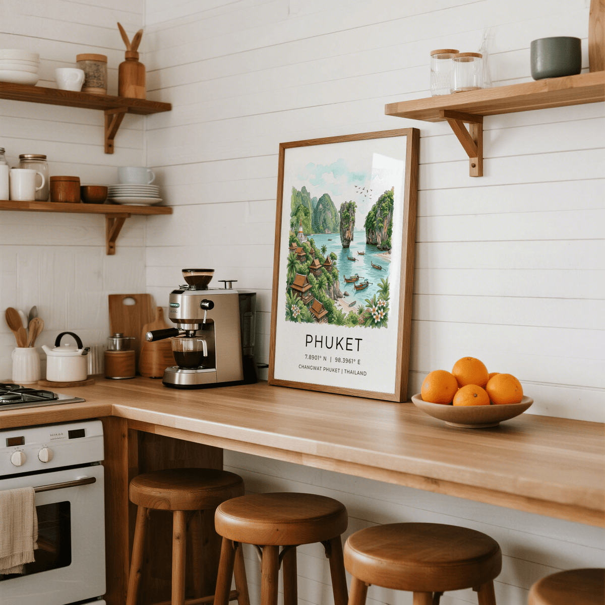 Print leaning on kitchen counter of Phuket beach bay in watercolour and botanical style with fruit bowl nearby