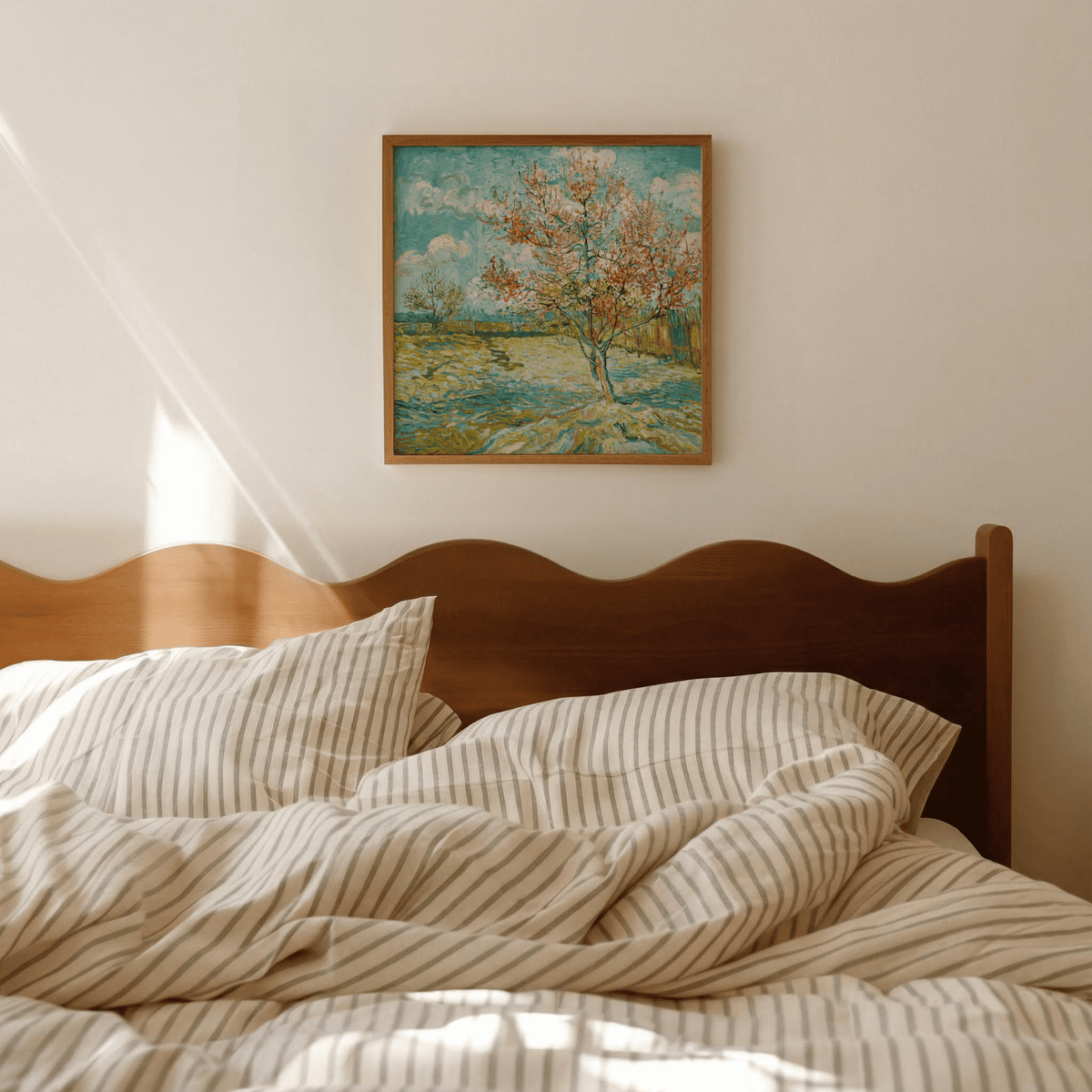 Impressionist wall art of a flowering tree with blue sky above a wooden bed