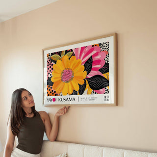 Floral Landscape Paintings framed print with a bright yellow flower and pink petals above a beige sofa
