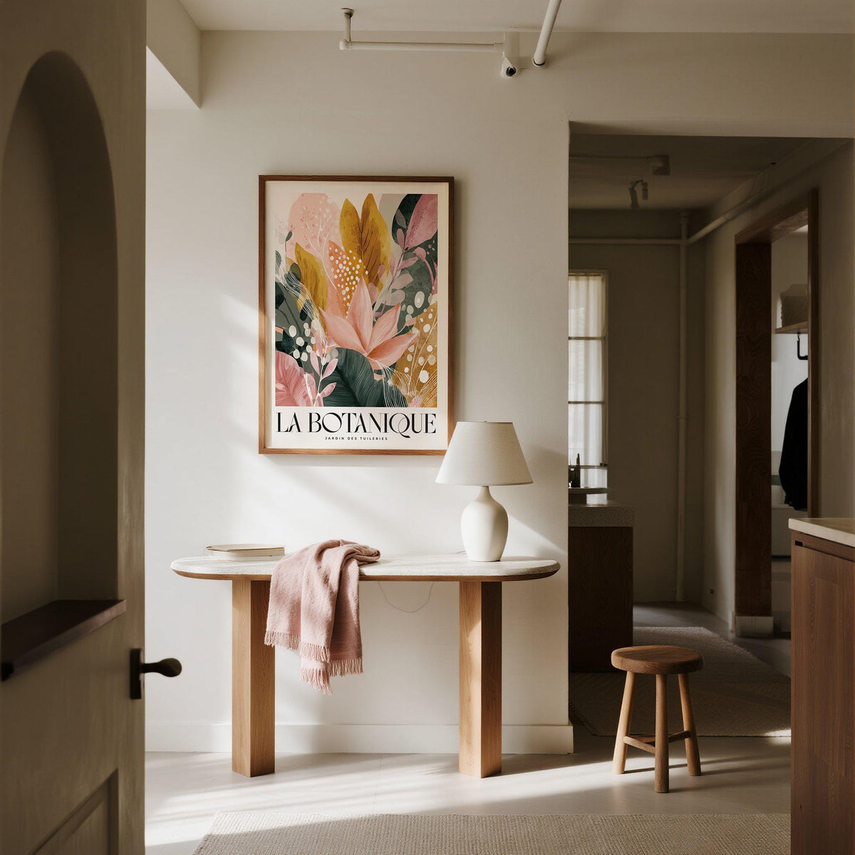 Flower prints botanical wall art with pink and mustard leaves above a console table with lamp