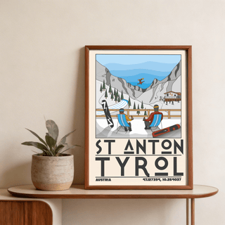 Framed St Anton Tyrol art print illustration of ski resort scene with blue sky on a wooden table with a plant