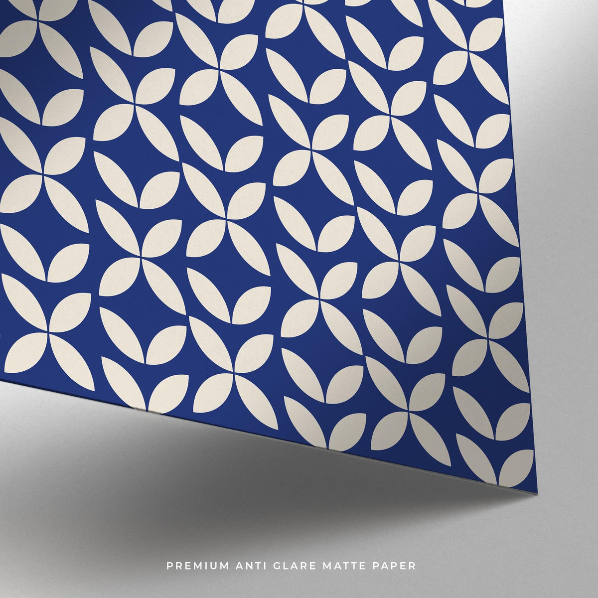 Close-up of blue modern wall art with white petal shapes on matte paper