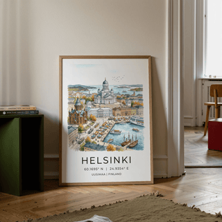 Print leaning on a floor of Helsinki watercolor art print showing cityscape with blue water and autumn trees next to green cabinet