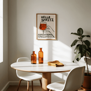 Spritz Print framed print of a minimalist spritz cocktail glass with orange and black colours above a dining table with amber glass bottles