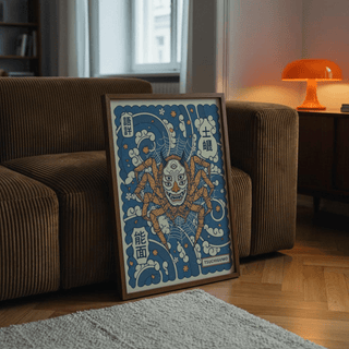 Print leaning on the floor of Tsuchigumo art showing a large spider with a mask in blue and brown near a brown sofa