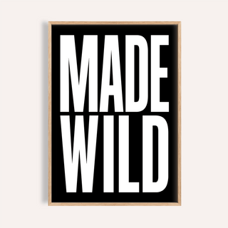 Framed close-up of Made Wild art print with white bold text on black background