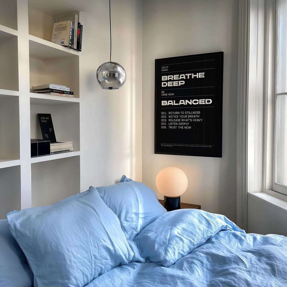 Phrases for Wall Art framed print with white text on black in a bedroom with blue bedding and a round table lamp