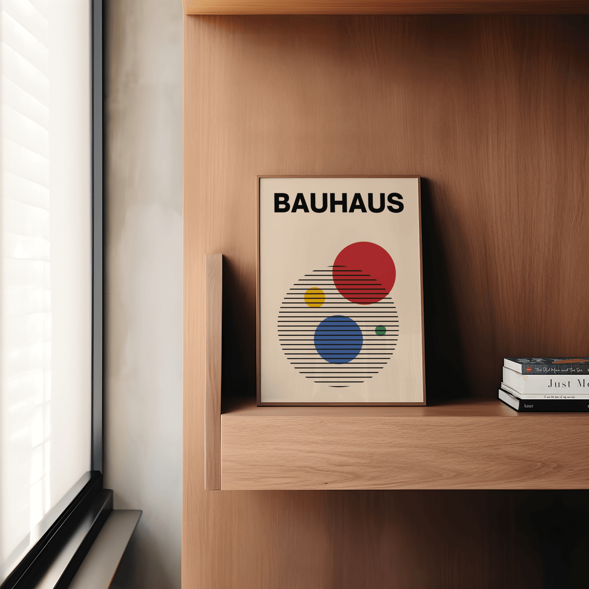 Abstract Circle wall art print leaning on a wooden shelf next to stacked books and a window