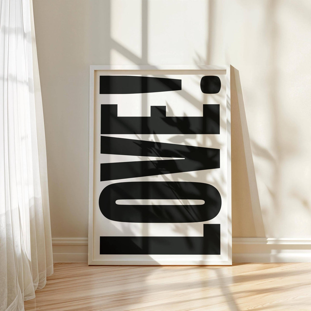 Large Motivational Posters leaning print of black LOVE typography in a white frame on a wooden floor with shadows
