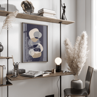 Abstract Modern Art print with overlapping beige and grey shapes above a wooden desk and lamp