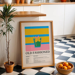 Drink wall art for kitchen leaning on floor next to a potted plant and a basket of oranges