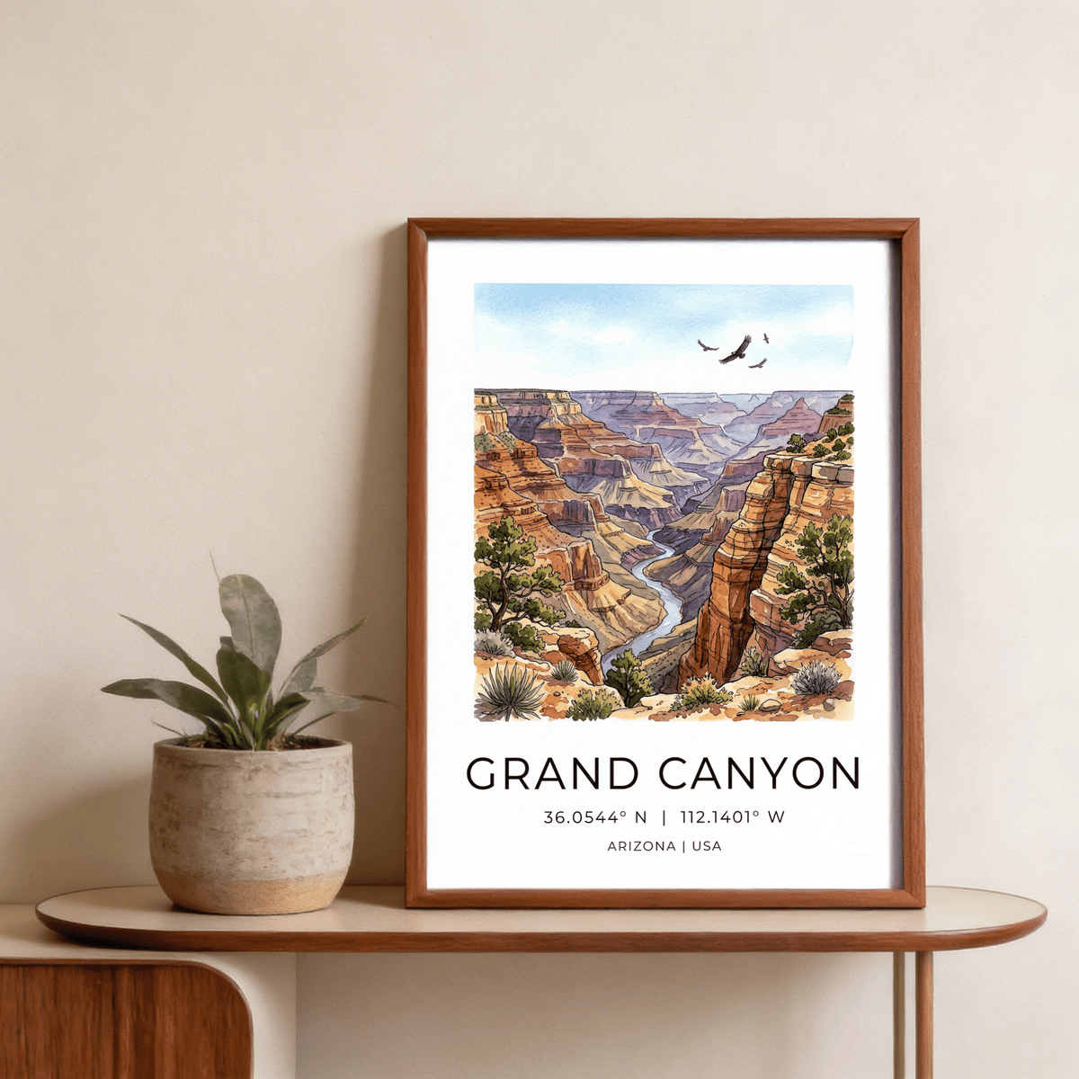 Grand Canyon art print in brown wooden frame on a table next to a green potted plant