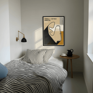 Print on a wall in a bedroom of Sao Paulo Race Circuit Diagram Poster with beige and black colours above a wooden side table