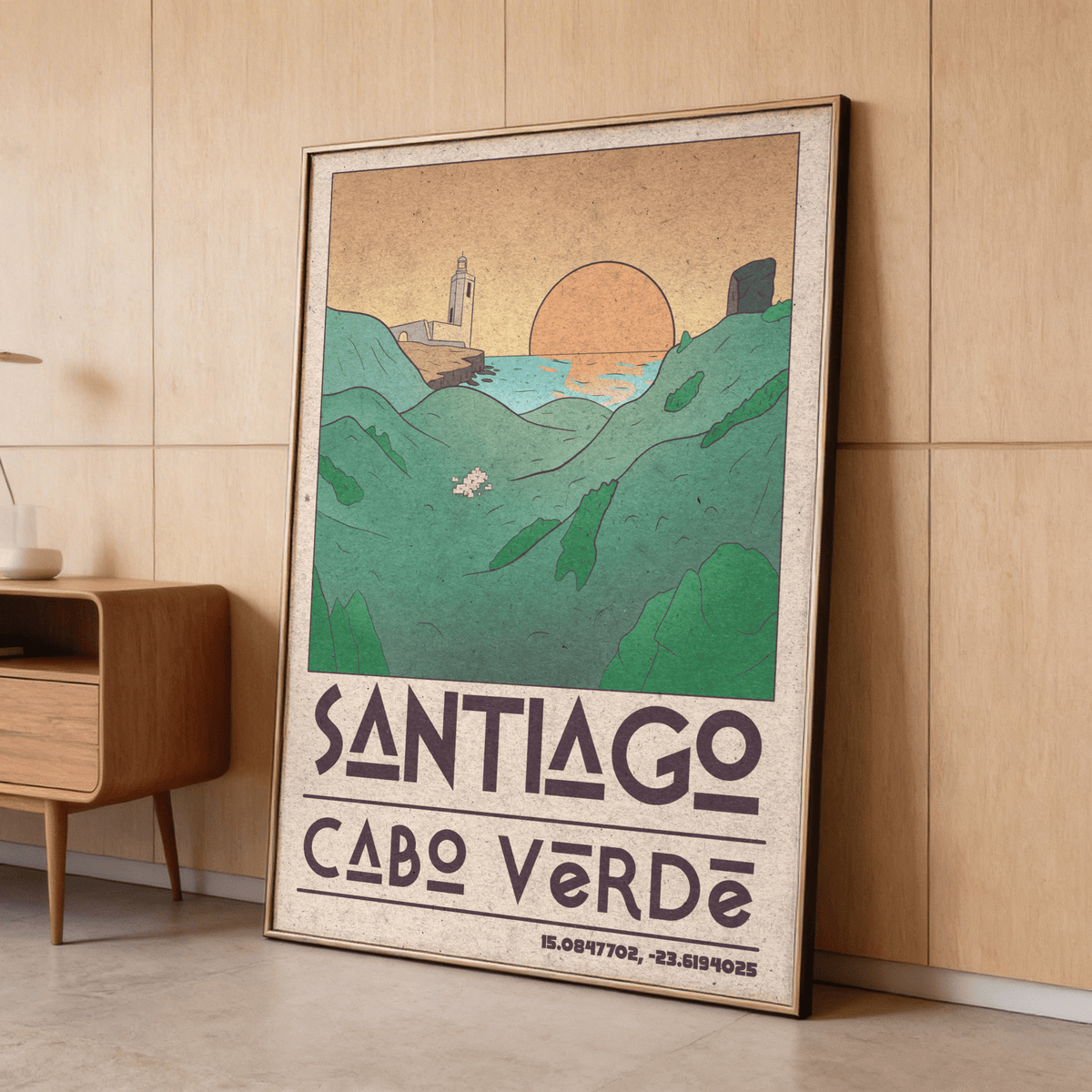Print leaning on the floor showing Santiago Cabo Verde Art Print with sunset and coastal hills in muted green and orange tones near