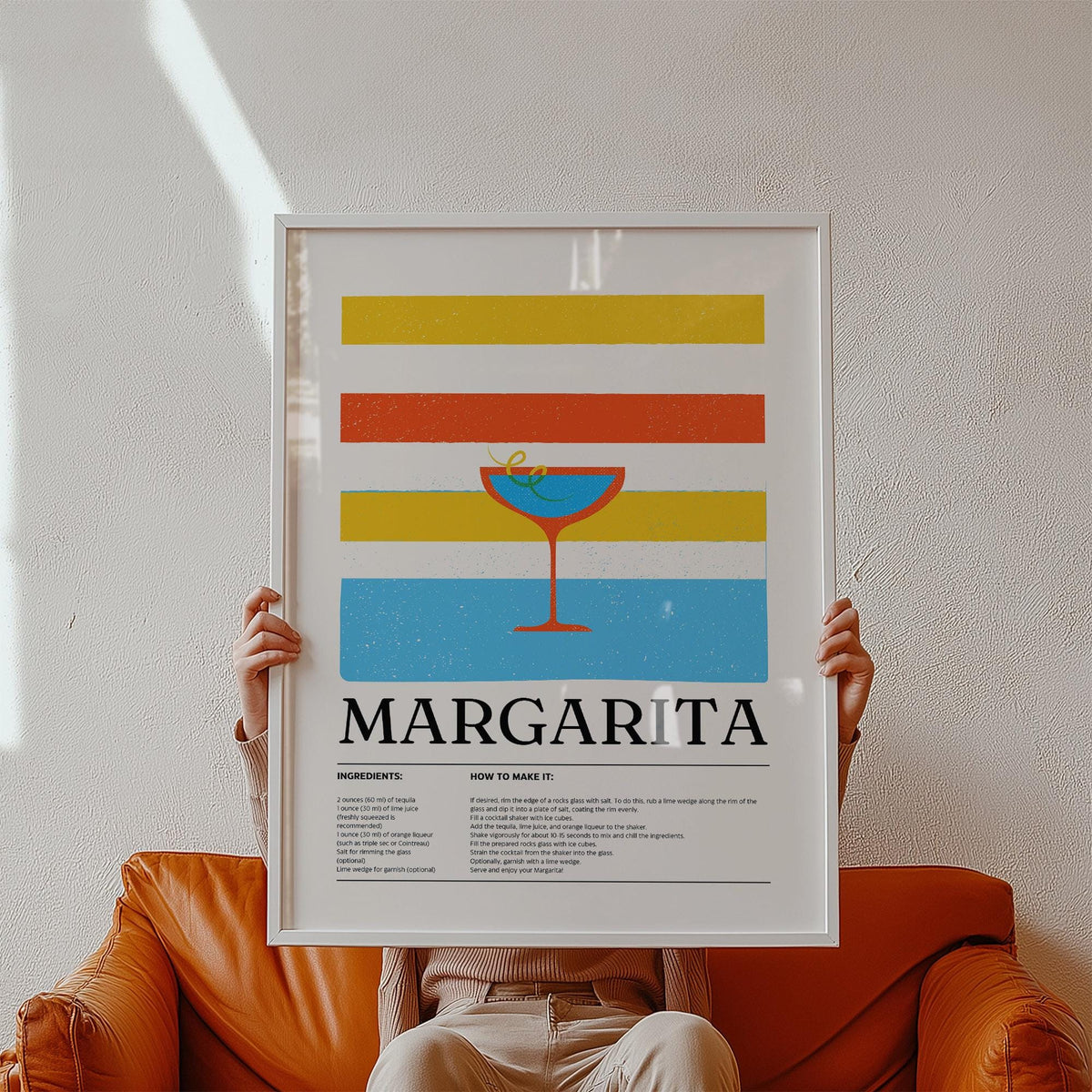 Framed Margarita wall art with colourful stripes held by person on orange sofa