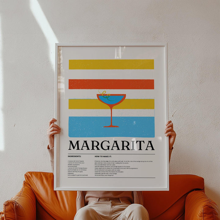 Framed Margarita wall art with colourful stripes held by person on orange sofa