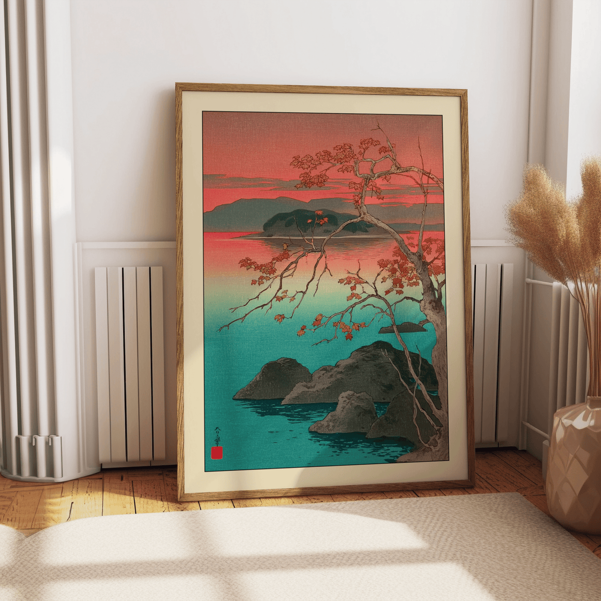 Print leaning on a floor next to dried flowers of Hasui Kawase Maple Leaves Print showing a Japanese-woodblock style autumn maple tree