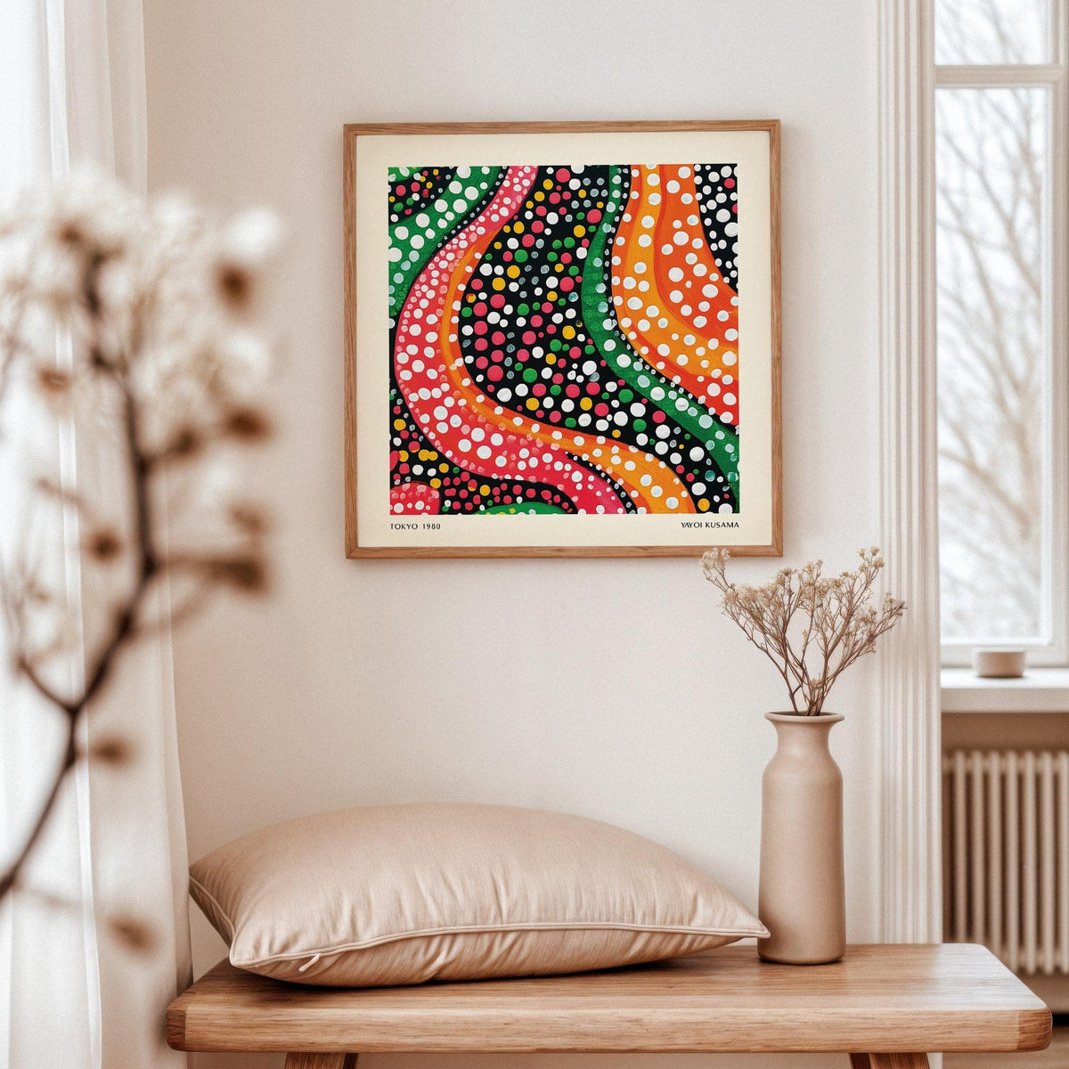 Abstract colorful art with vibrant wavy lines and dots framed on a wall above a beige cushion
