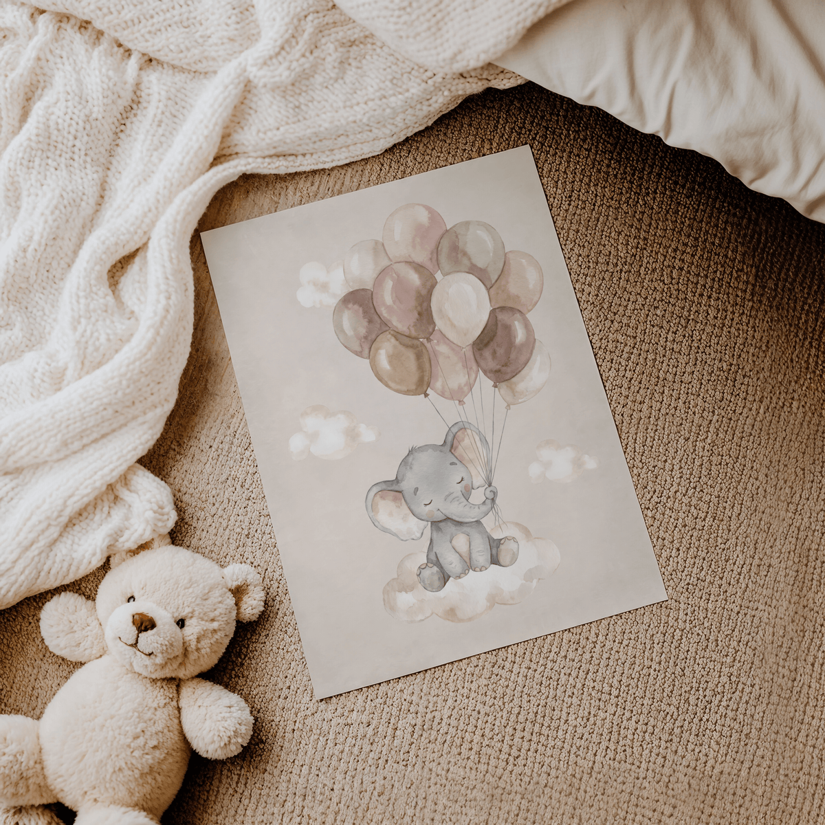 Moon And Sun Print laid on carpet next to a teddy bear showing a baby elephant with balloons in soft colours